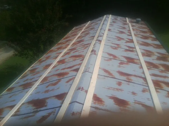 Rusted metal roof panels with new wood purlins before replacement — Storm Damage Roof Repair in Newton by Roofing Brothers